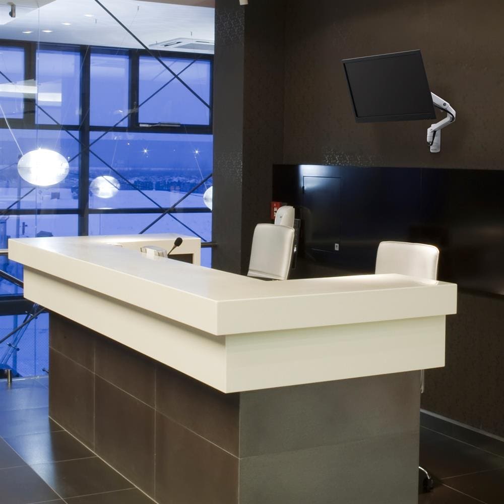 Ergotron MXV Wall Monitor Arm (White) - mounted to wall behind reception counter